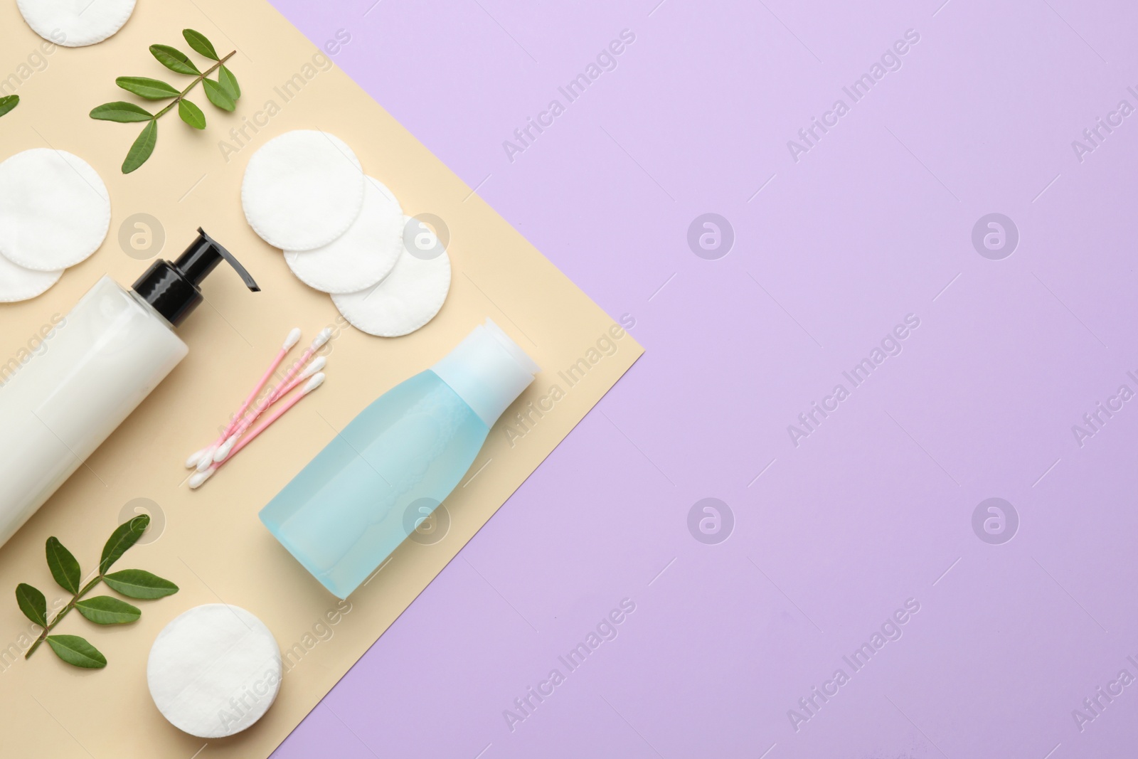 Photo of Cotton pads, swabs, leaves and makeup removal products on color background, flat lay. Space for text