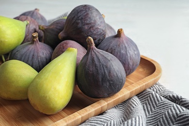 Plate with assorted ripe figs on table. Tropical fruit