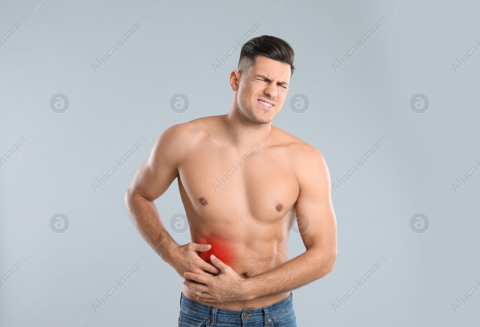 Photo of Man suffering from liver pain on grey background