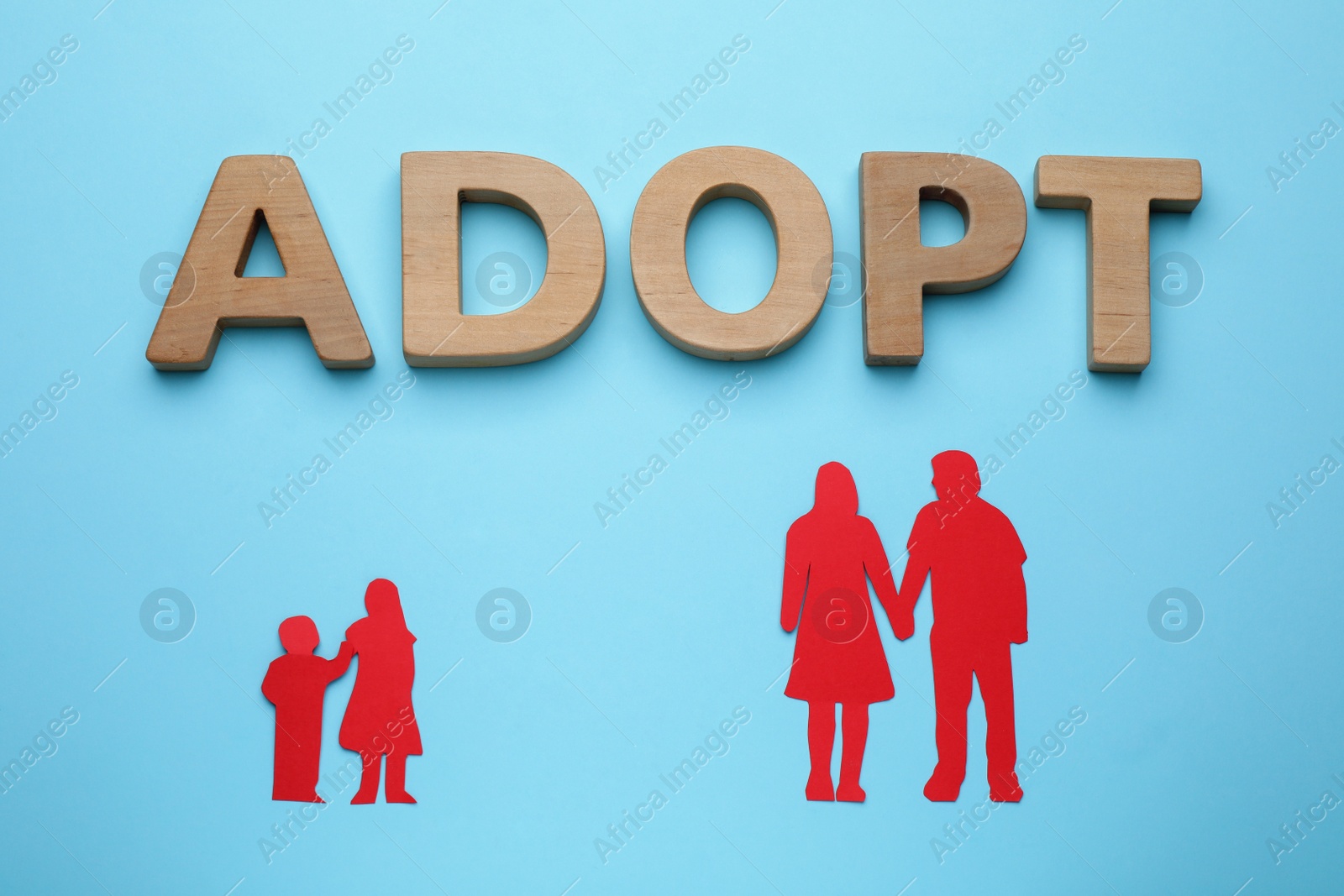 Photo of Figures of parents with children and word Adopt on light blue background, flat lay