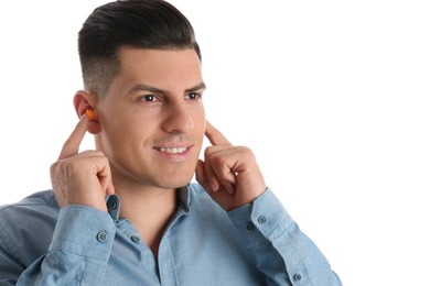 Photo of Man inserting foam ear plugs on white background