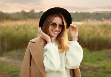 Beautiful young woman wearing stylish autumn clothes outdoors
