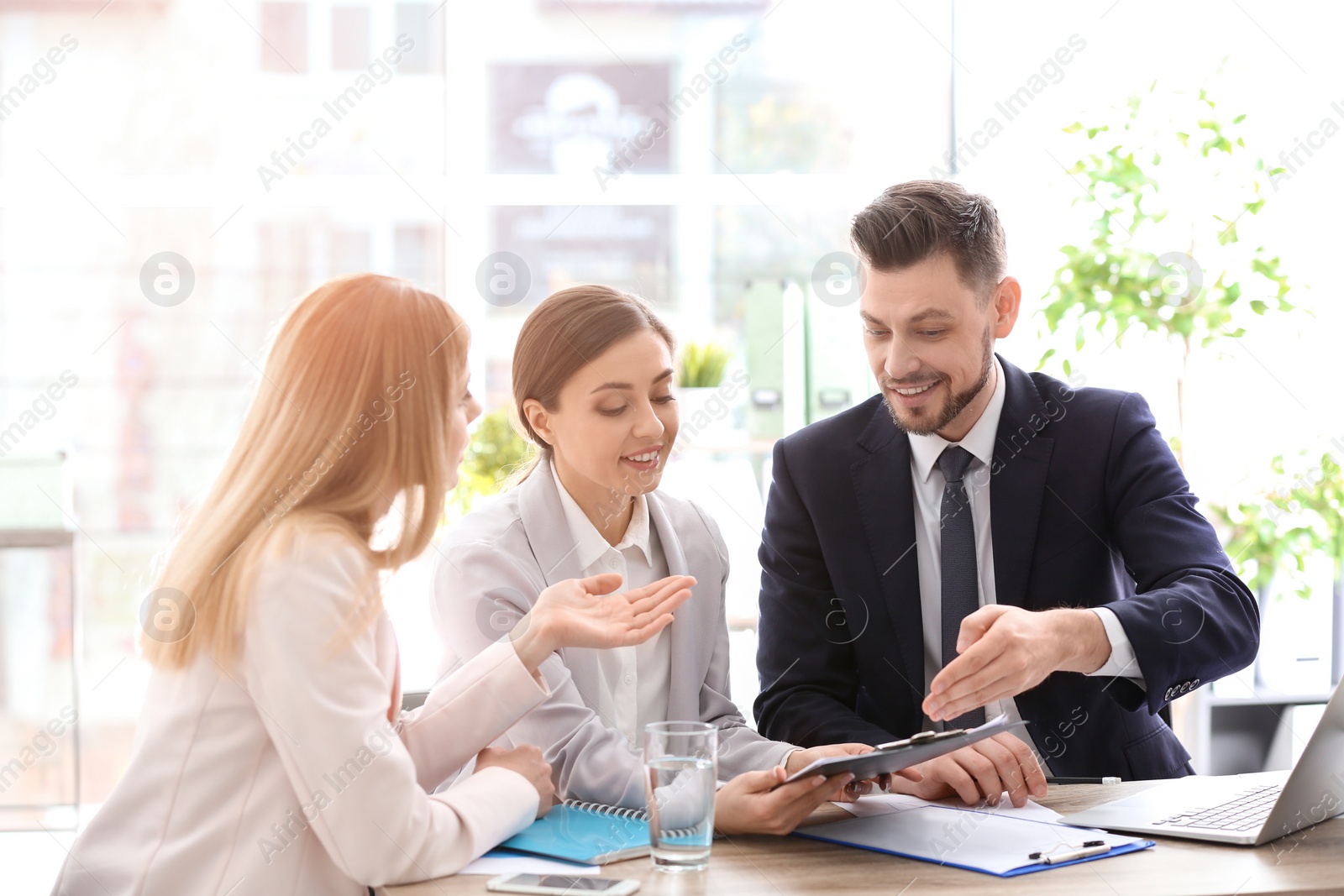 Photo of Young consultant working with clients in office