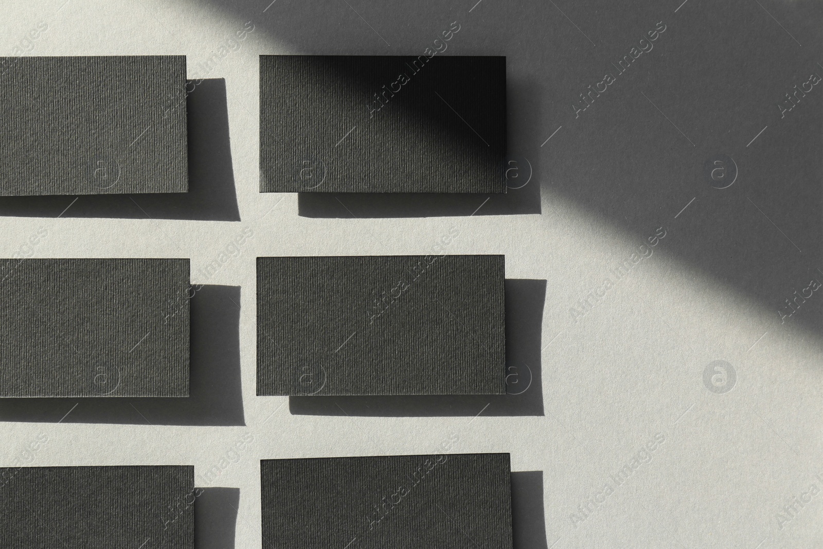 Photo of Blank black business cards on light background, flat lay. Mockup for design