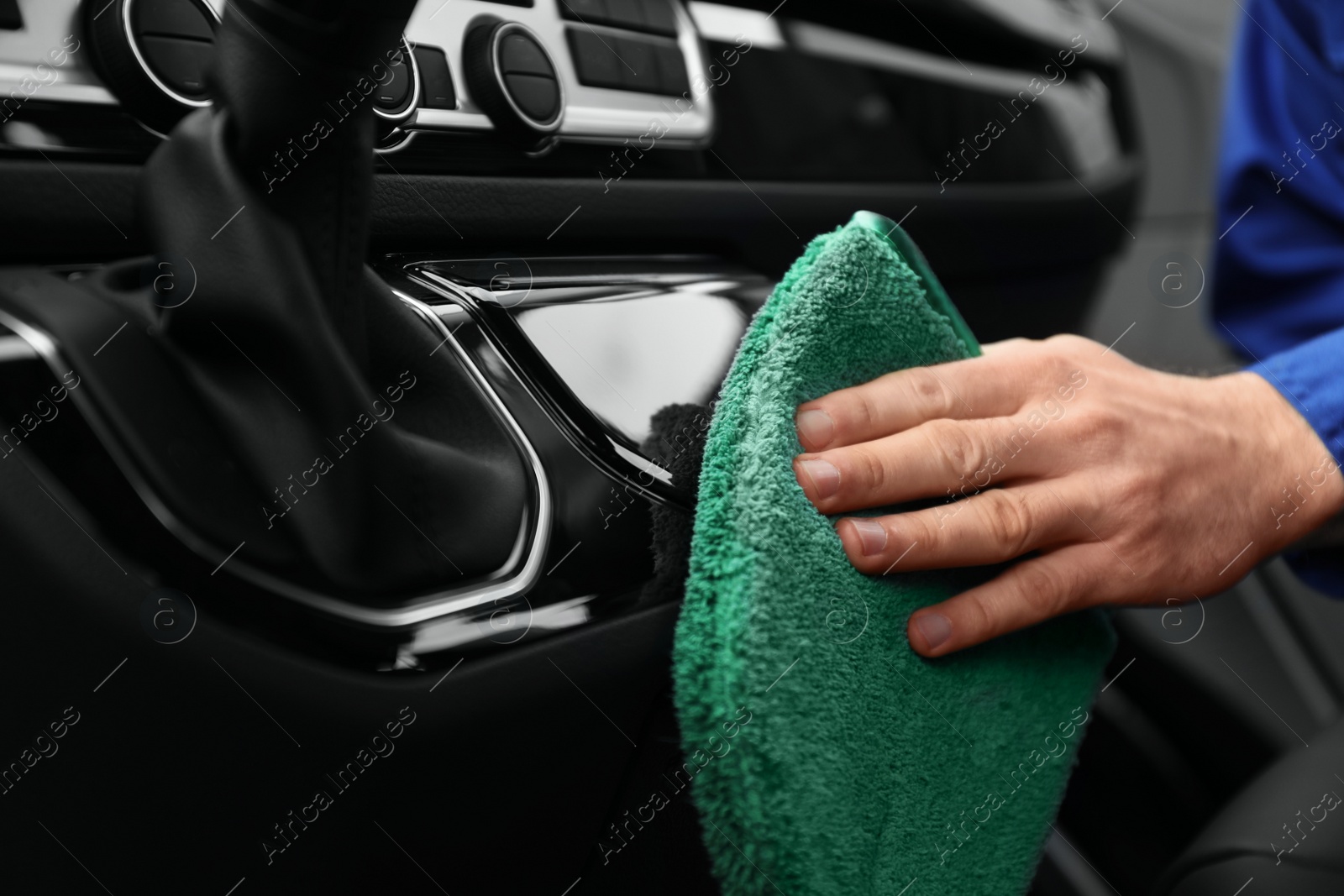 Photo of Car wash worker cleaning automobile interior, closeup