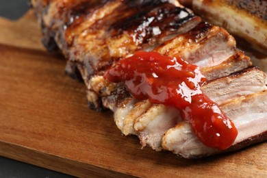 Photo of Delicious grilled ribs with sauce on table, closeup