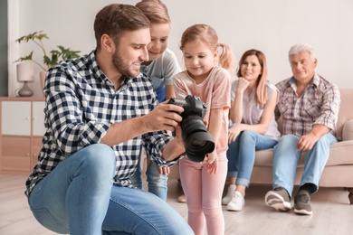Photo of Professional photographer with camera and little kids in studio