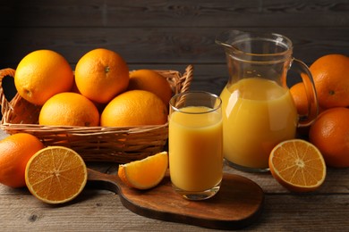 Tasty fresh oranges and juice on wooden table