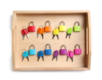 Photo of Set of colorful locks and matching keys in box isolated on white, top view. Montessori toy