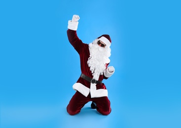 Photo of Portrait of Santa Claus with sunglasses on light blue background