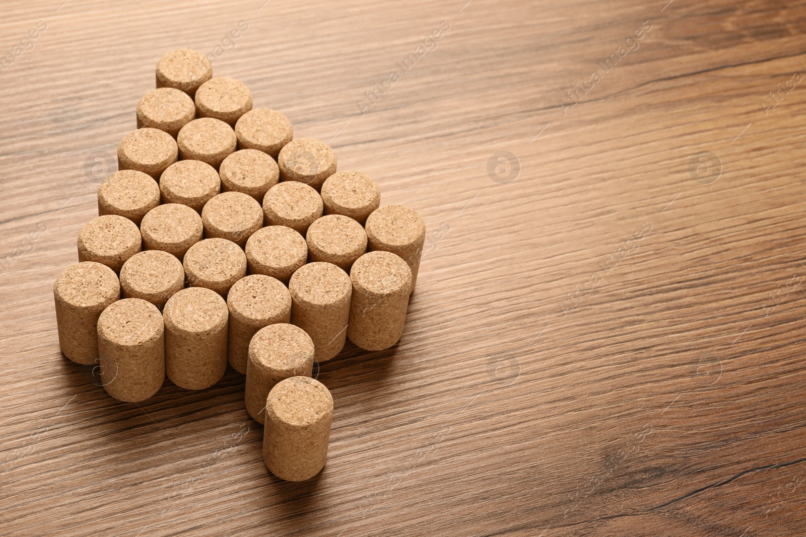 Photo of Christmas tree made of wine corks on wooden table. Space for text