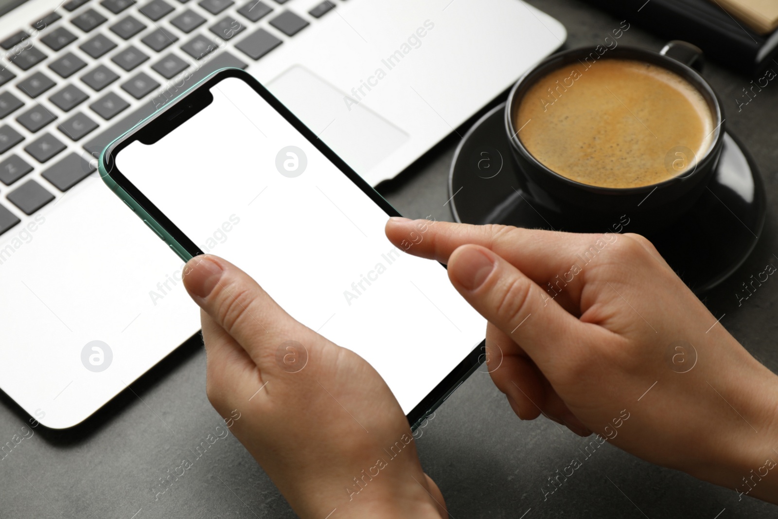 Photo of MYKOLAIV, UKRAINE - JULY 8, 2020: Woman using Iphone 11 Pro Max with blank screen at workplace, closeup