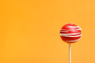 Photo of Bright delicious cake pop on color background. Space for text