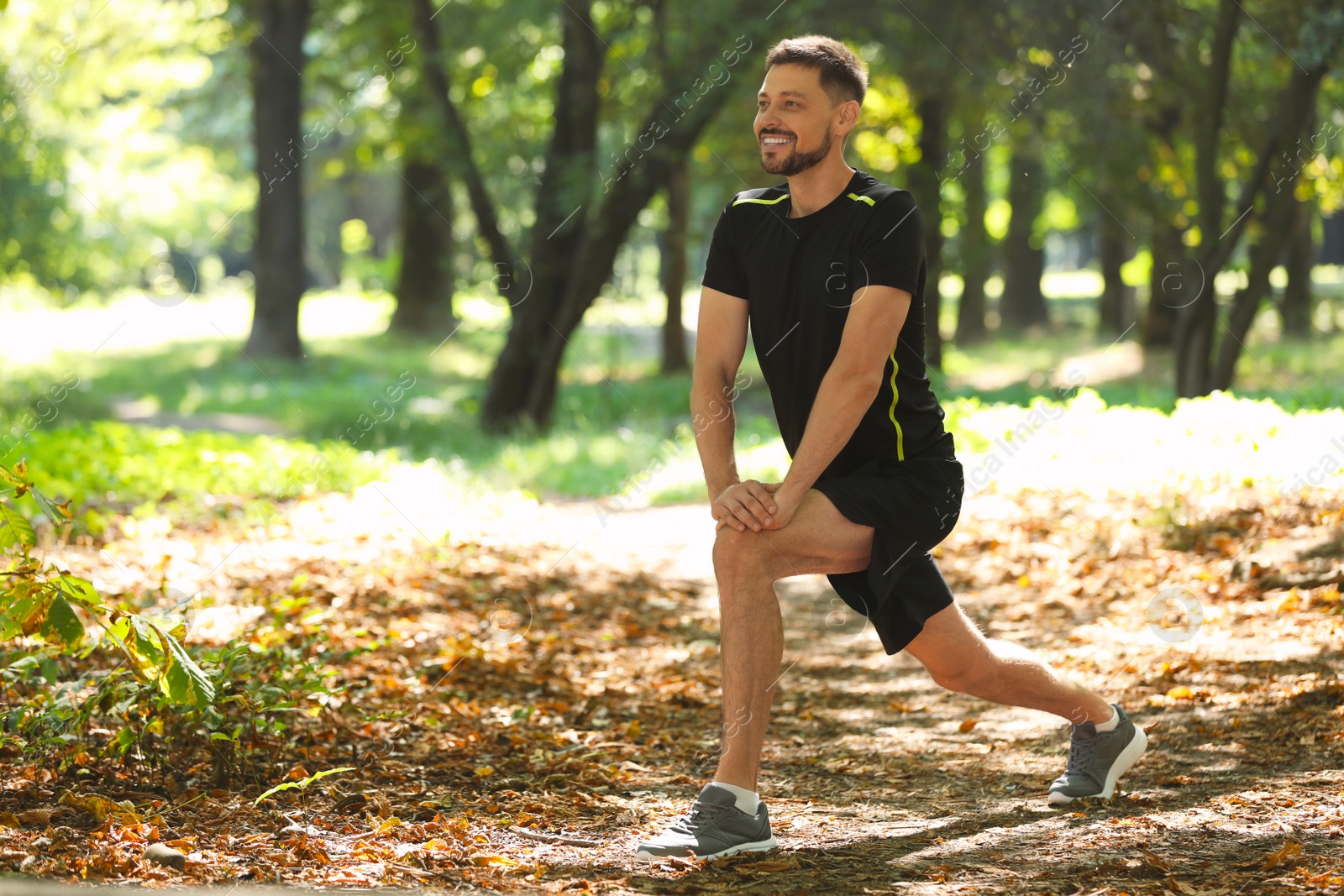 Photo of Handsome man doing morning exercise in park, space for text