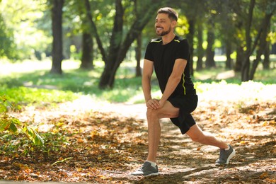 Photo of Handsome man doing morning exercise in park, space for text