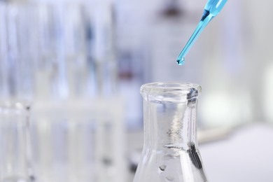 Photo of Laboratory analysis. Dripping liquid into flask on table, closeup. Space for text