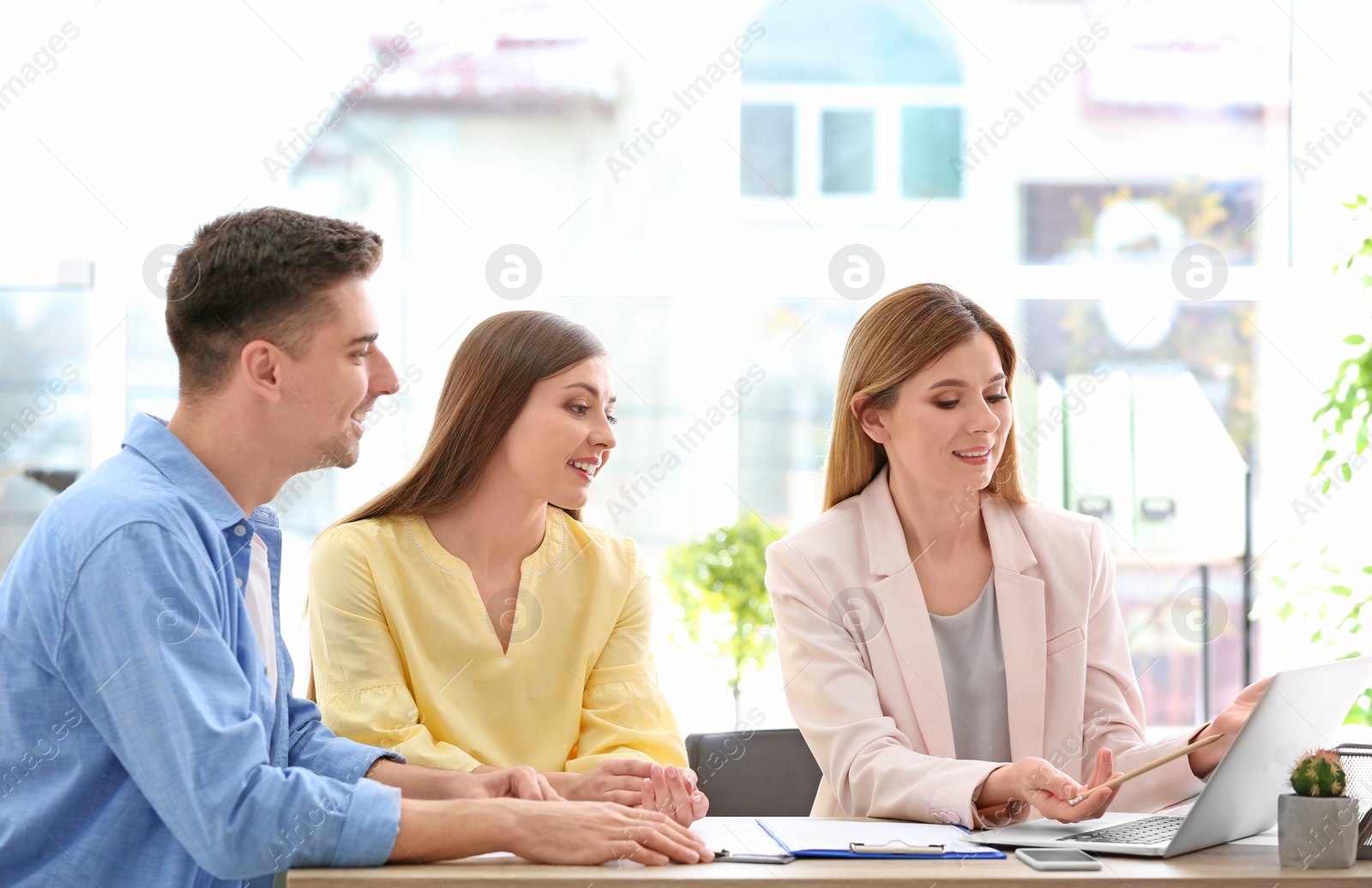 Photo of Young couple meeting with consultant in office