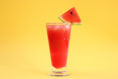 Photo of Delicious drink with piece of watermelon and ice cubes on yellow background