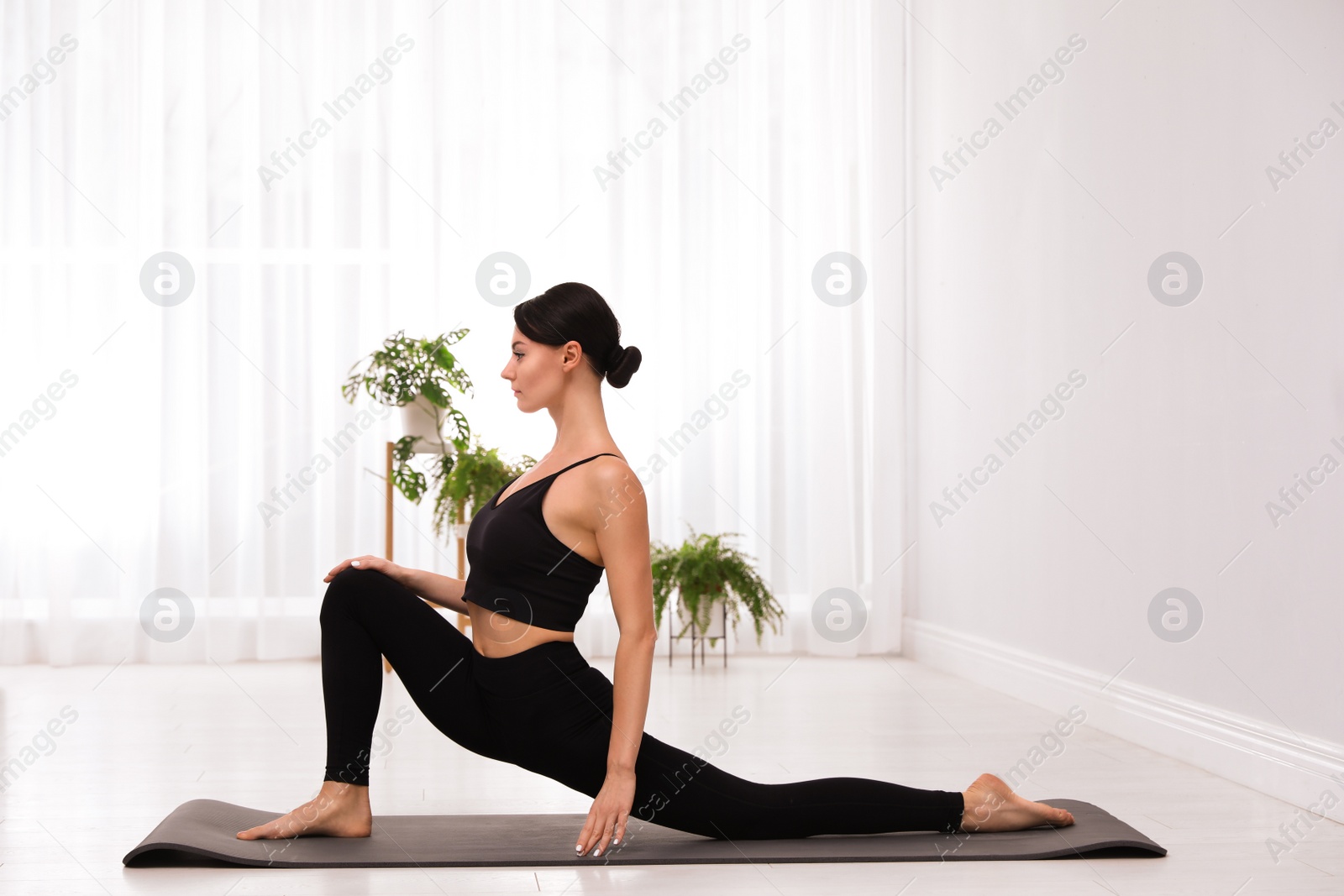 Photo of Professional young acrobat practicing yoga at home