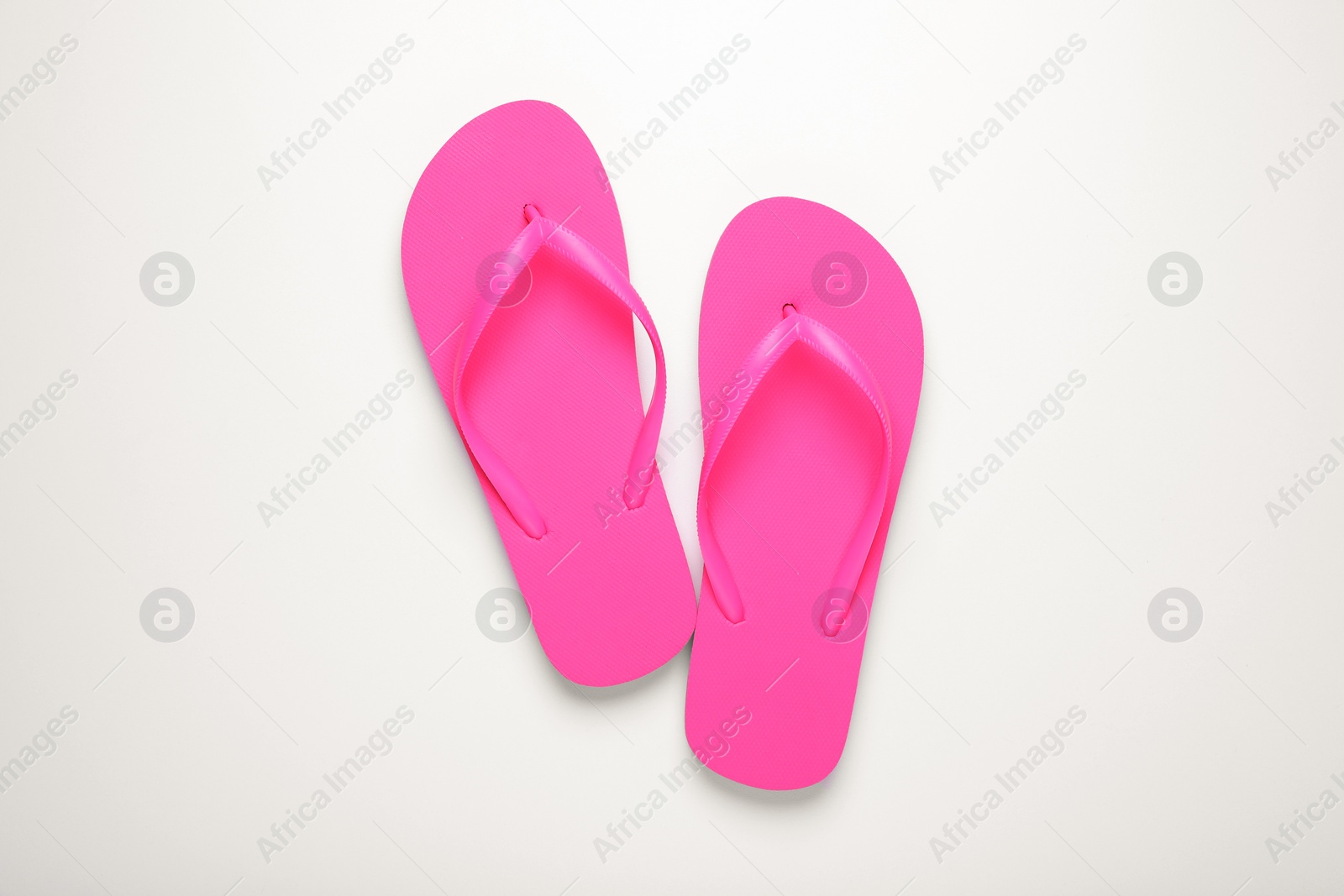 Photo of Stylish pink flip flops on white background, top view