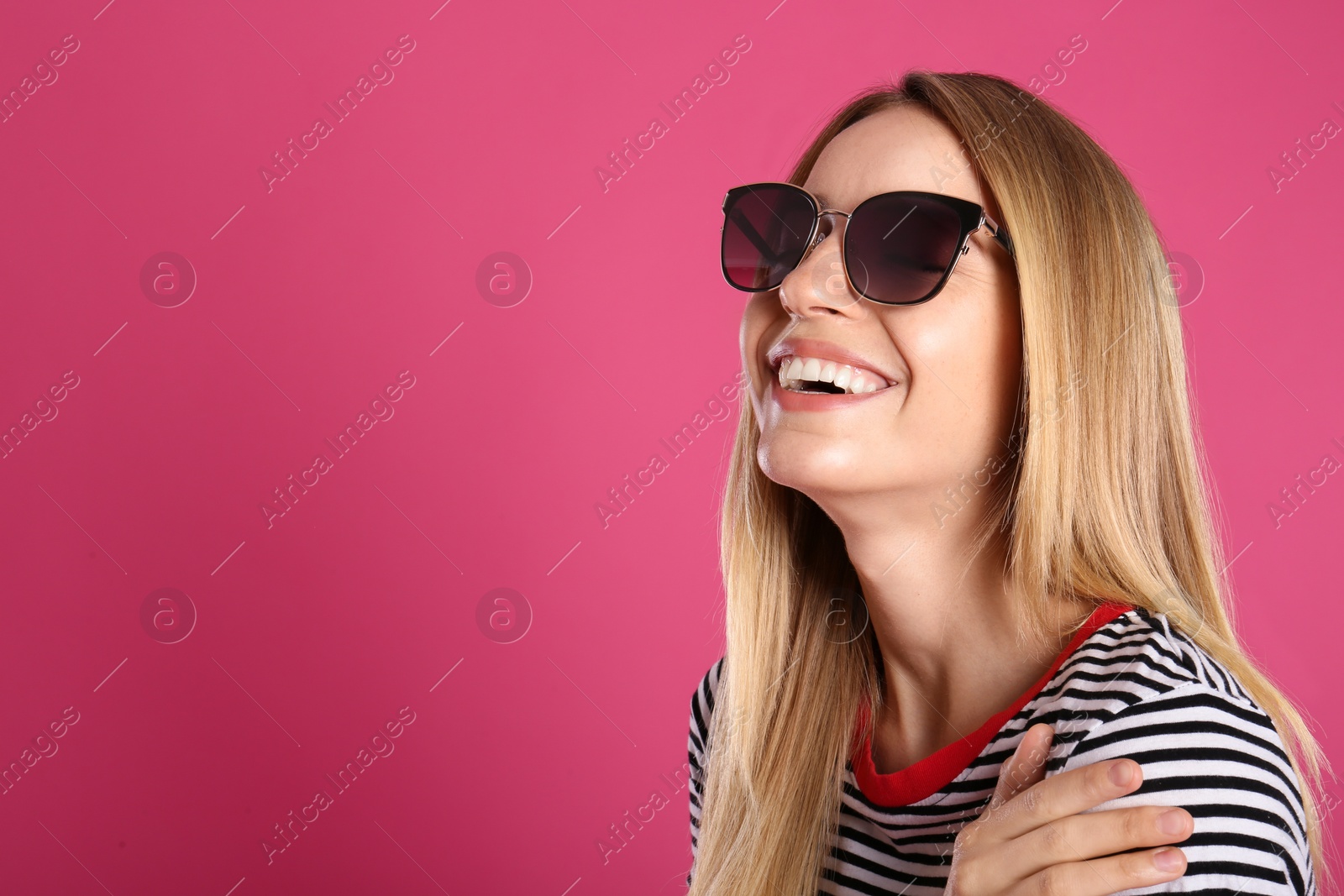 Photo of Beautiful woman in stylish sunglasses on pink background. Space for text