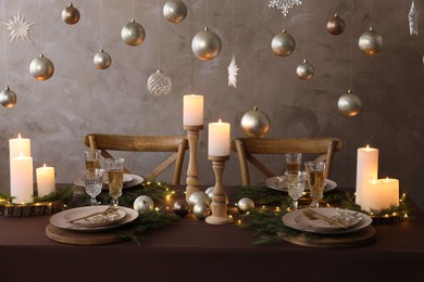 Photo of Christmas table setting with burning candles and festive decor