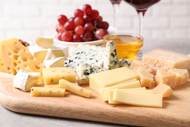 Plate with different sorts of cheese on grey table, closeup