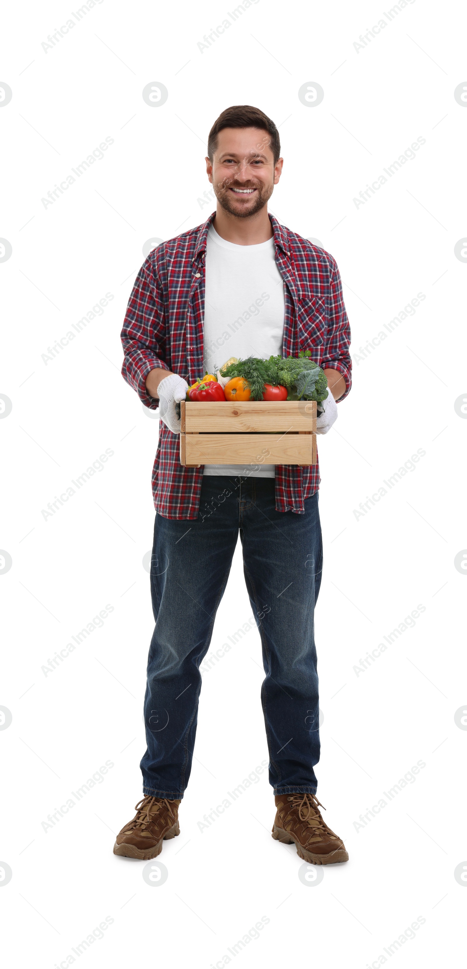 Photo of Harvesting season. Happy farmer holding wooden crate with vegetables on white background