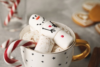 Funny marshmallow snowman in cup of hot drink, closeup