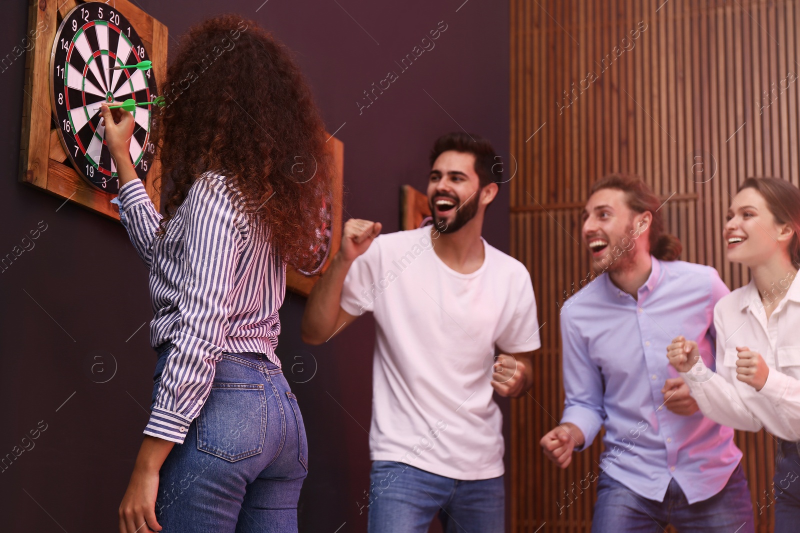 Photo of Group of friends playing darts in bar