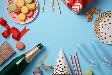 Photo of Creative flat lay composition with bottle of champagne and party accessories on color background. Space for text