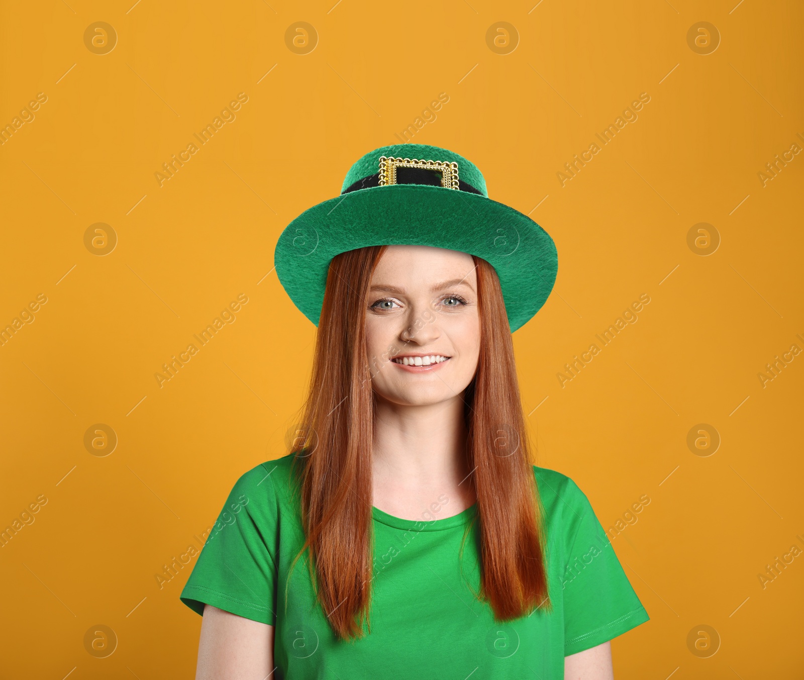 Image of St. Patrick's day party. Pretty woman in green leprechaun hat on golden background