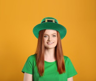 St. Patrick's day party. Pretty woman in green leprechaun hat on golden background