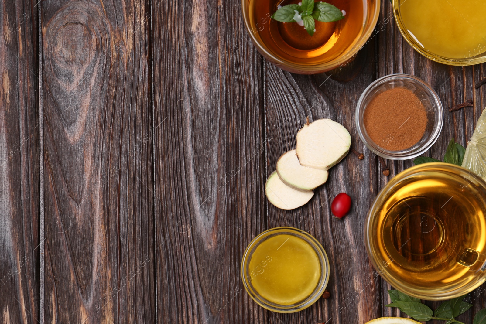 Photo of Flat lay composition of tea with honey and ingredients on wooden table. Space for text