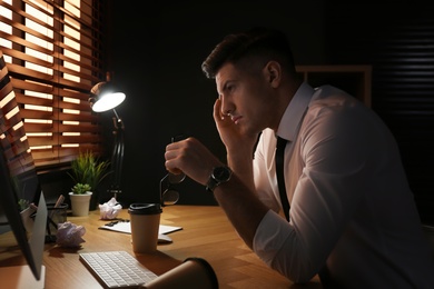 Businessman stressing out at workplace late in evening