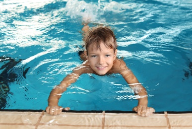 Photo of Cute little boy in indoor swimming pool