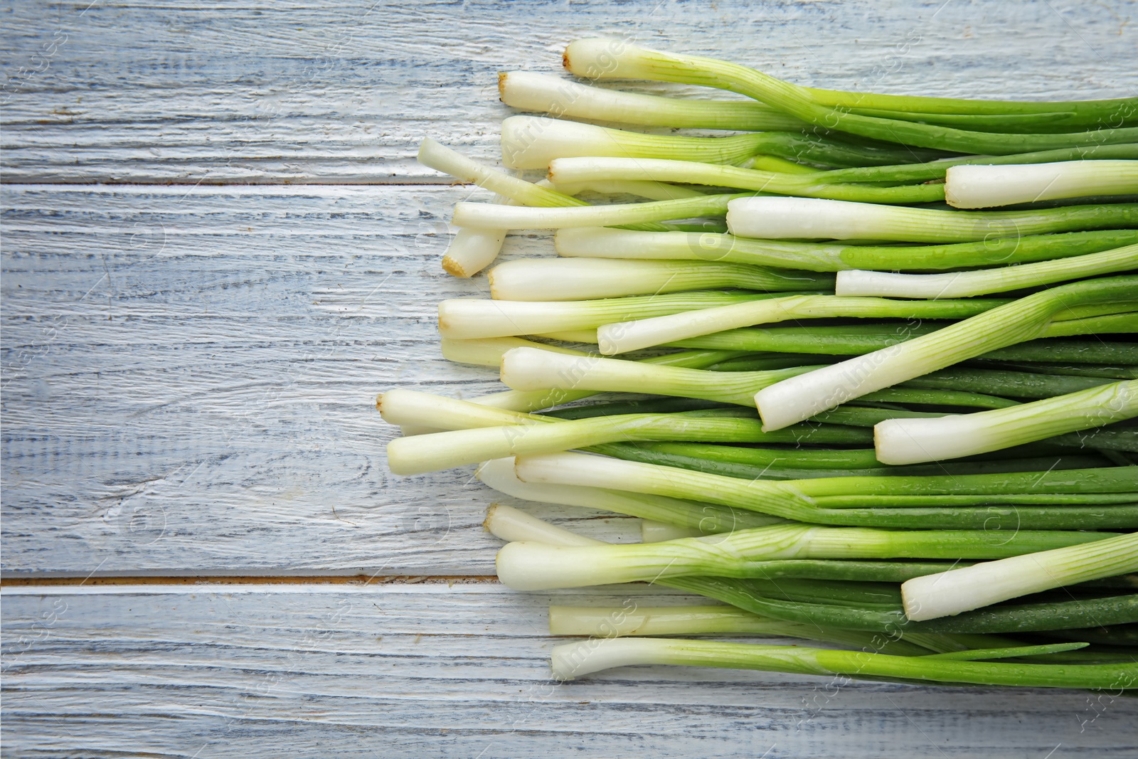 Photo of Fresh green onion on wooden table, top view