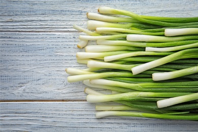 Fresh green onion on wooden table, top view