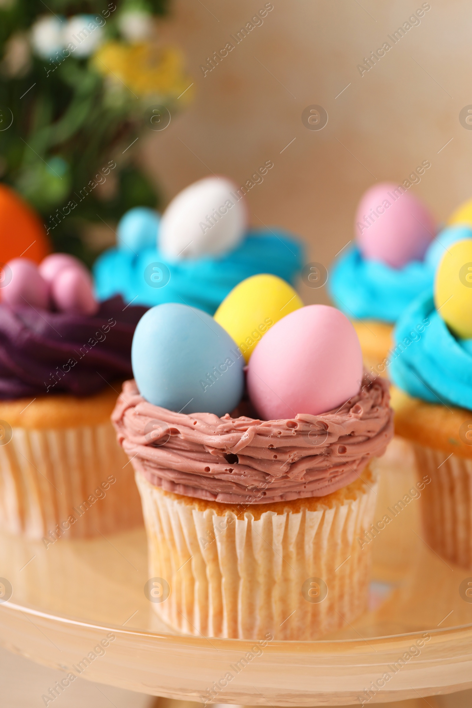 Photo of Tasty decorated Easter cupcakes on stand, closeup