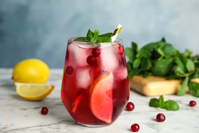 Tasty refreshing cranberry cocktail and fresh ingredients on white marble table