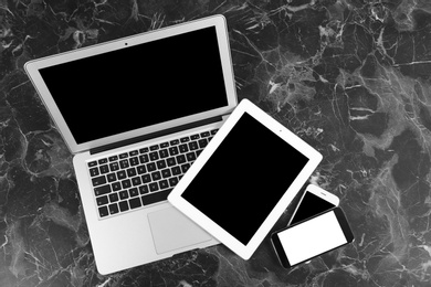 Photo of Devices with blank screens on marble background, top view. Mock up for design