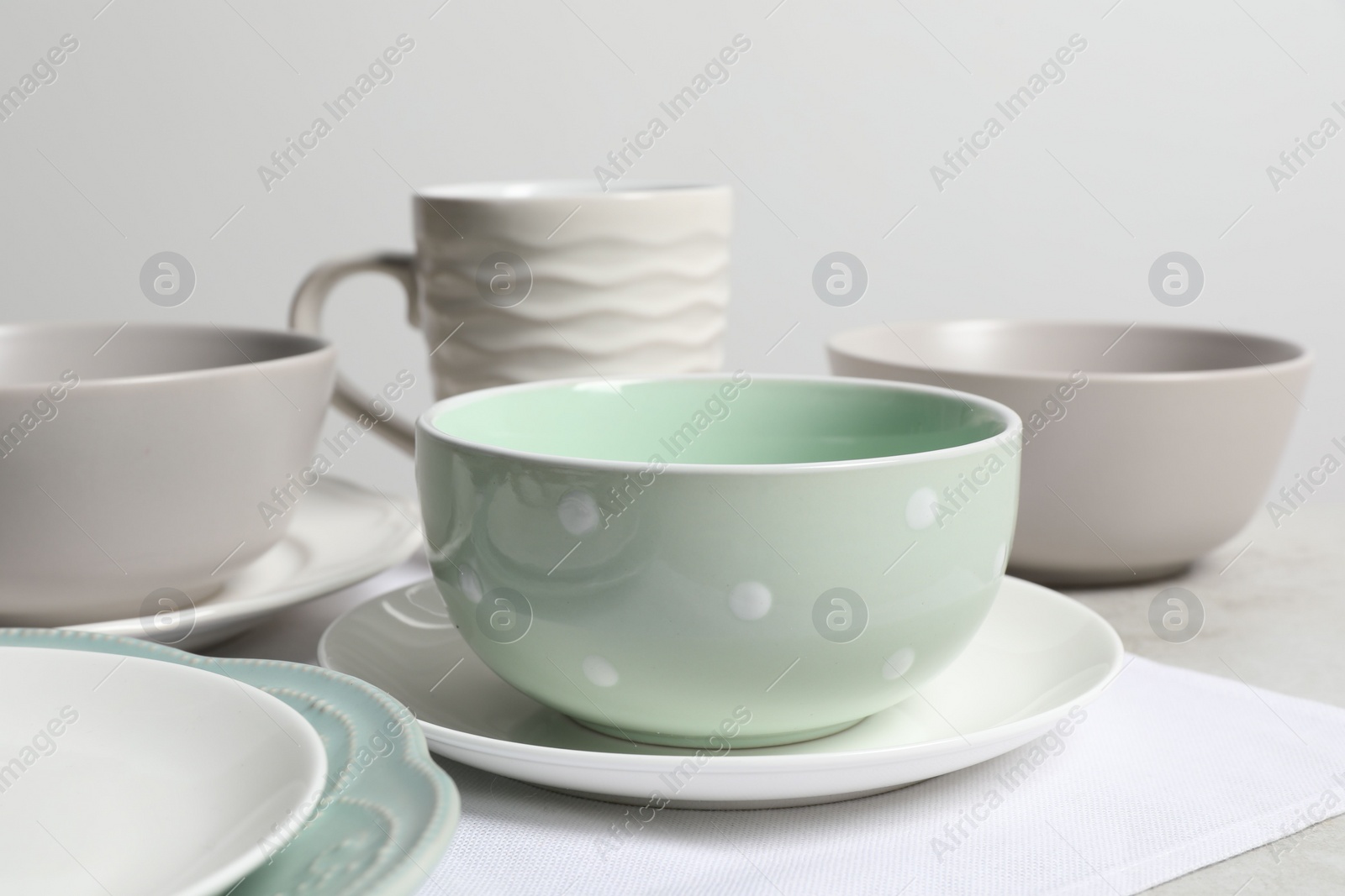 Photo of Beautiful ceramic dishware and cup on table