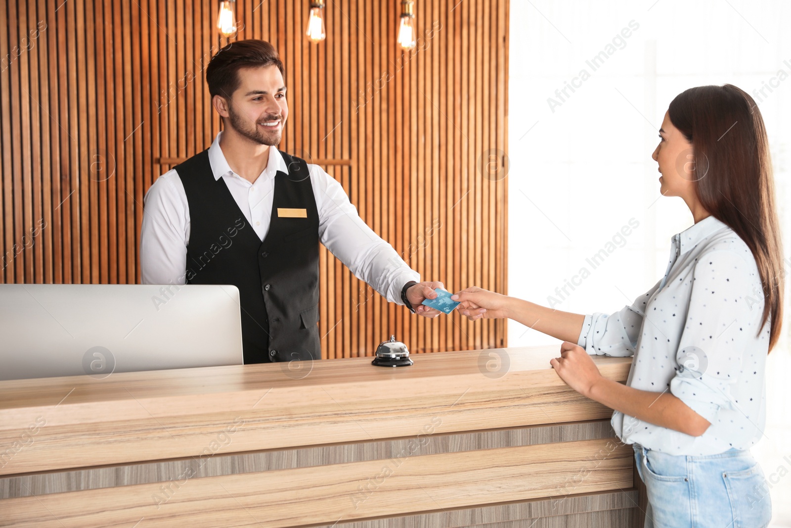 Photo of Client paying with credit card for service to receptionist at desk in lobby