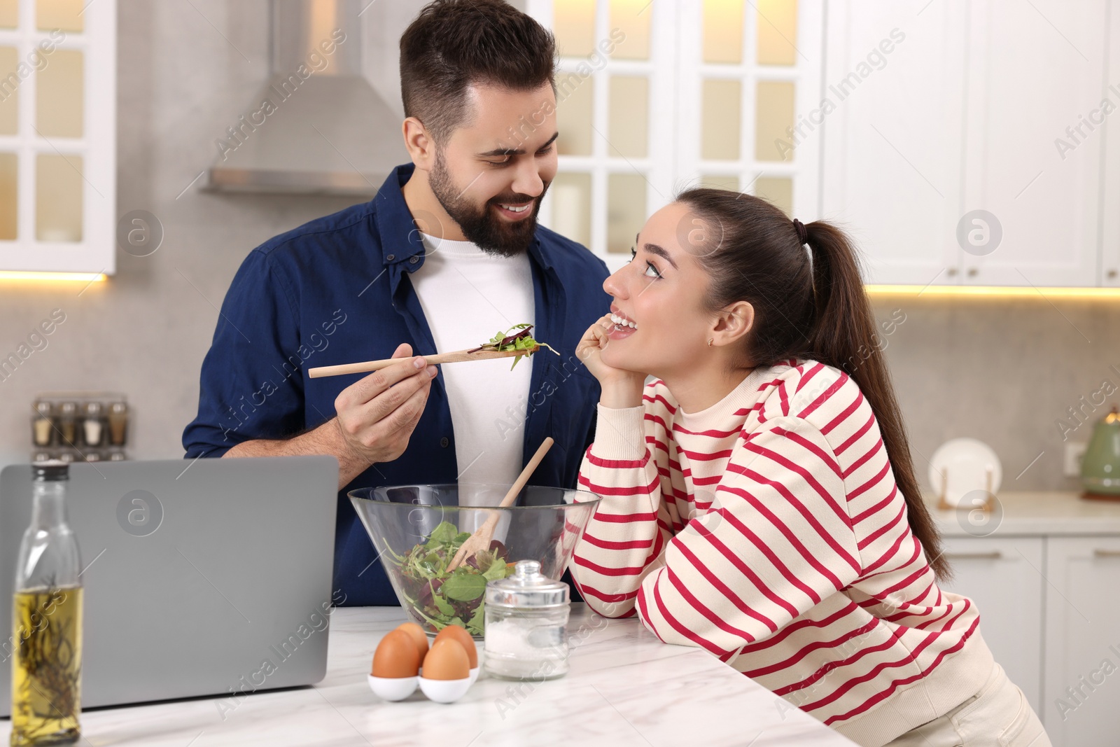 Photo of Happy lovely couple cooking together in kitchen