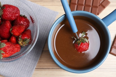 Flat lay composition with chocolate fondue on wooden background