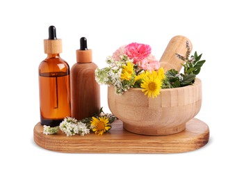 Photo of Bottles of essential oil and wooden mortar with different flowers on white background