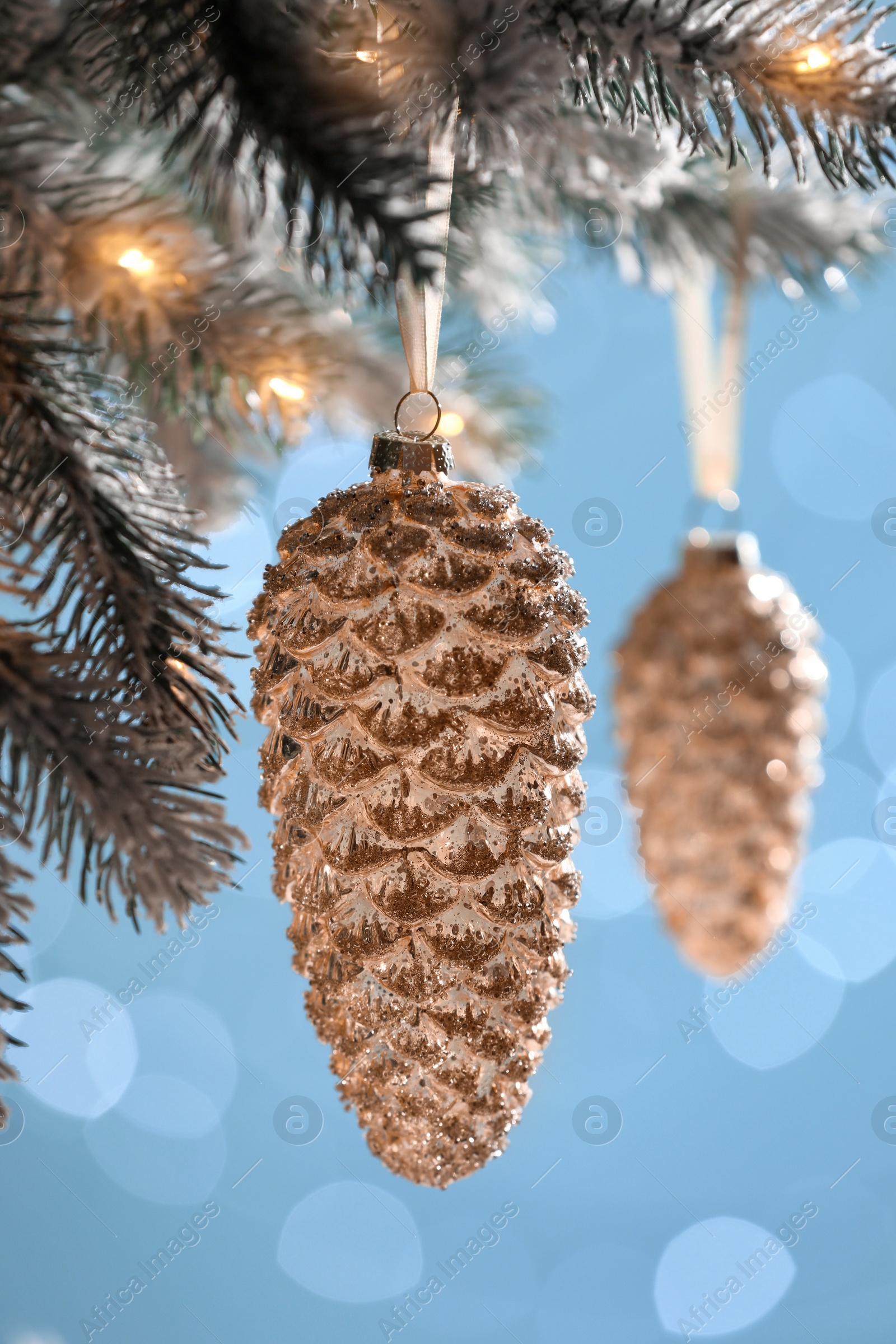 Photo of Christmas tree decorated with holiday baubles against blurred lights, closeup