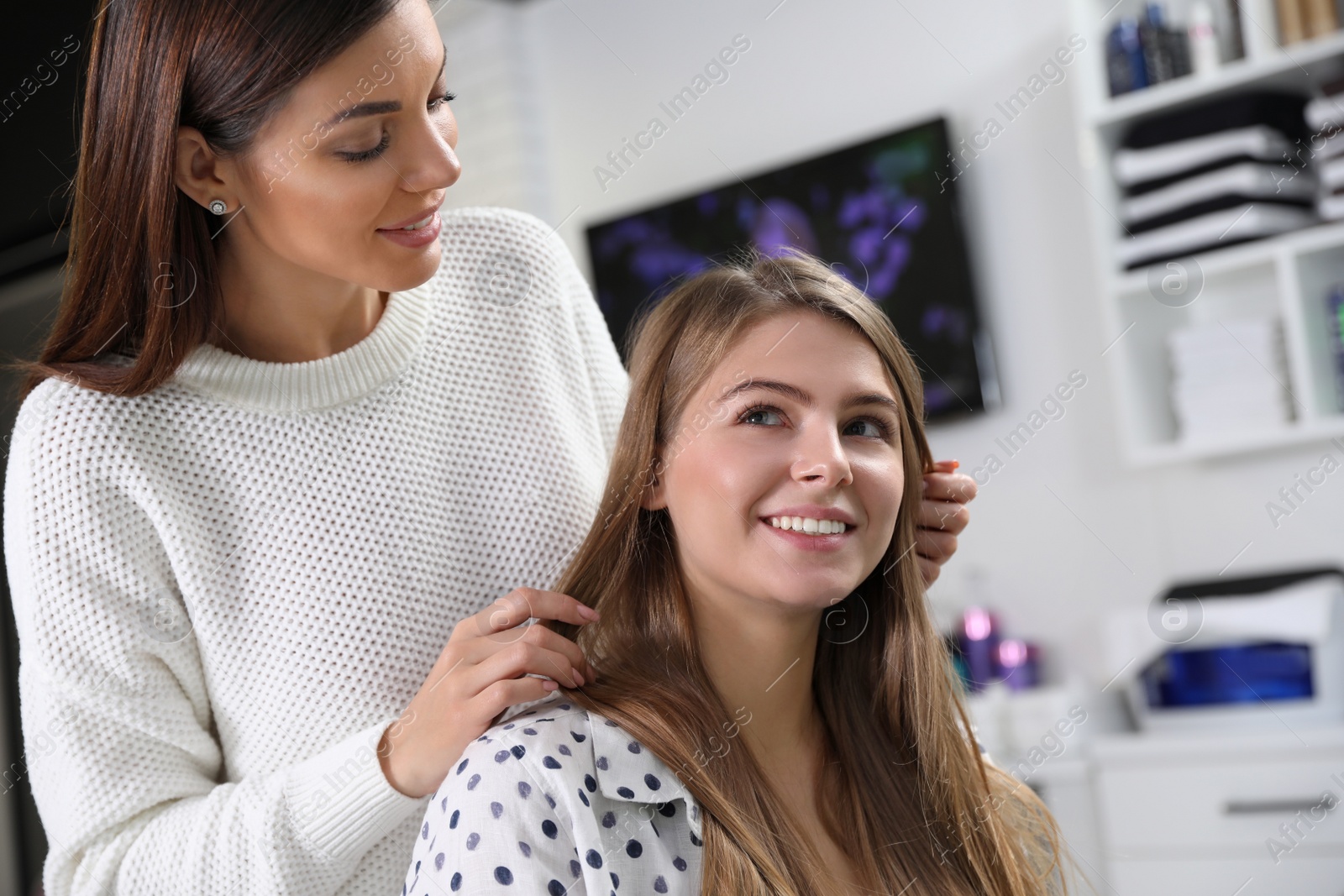 Photo of Professional hairdresser working with client in beauty salon