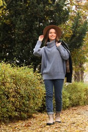 Photo of Beautiful young woman wearing stylish clothes in autumn park