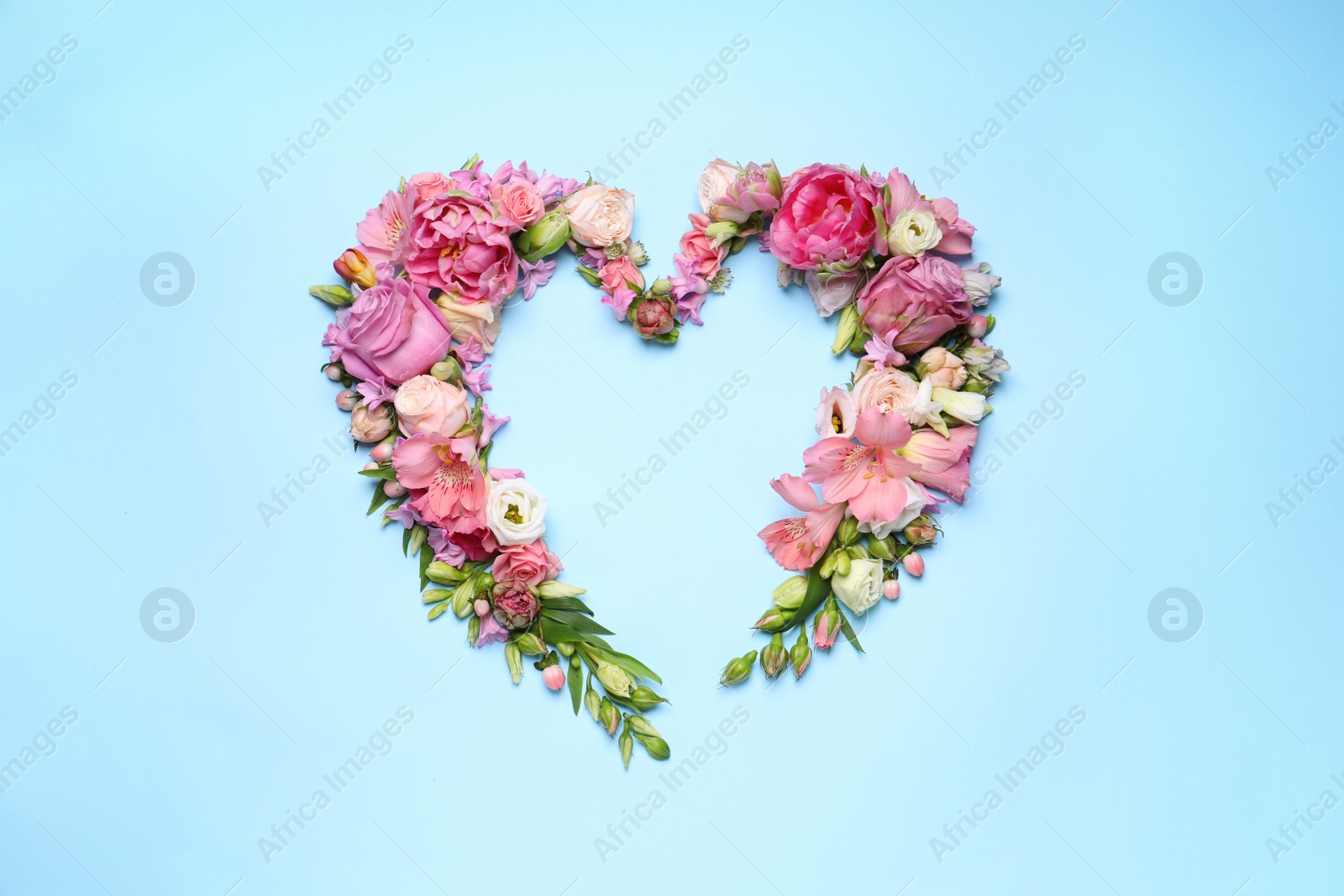 Photo of Beautiful heart shaped floral composition on turquoise background, flat lay